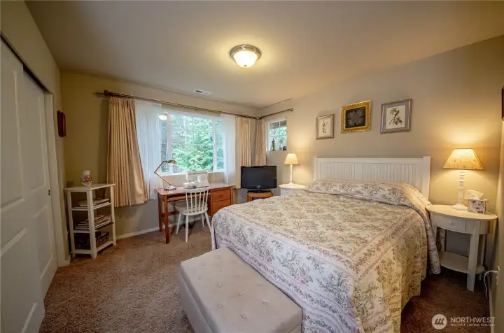 The upstairs guest bedroom is tucked away in the back of home and offers peaceful views of the garden space.