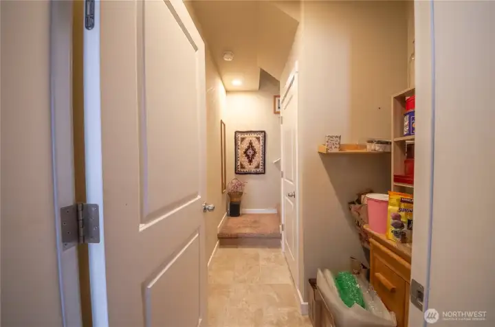 Did we mention this home has LOTS of storage? Pictured here is the door from the garage into the house. On the right is an area where you can add shelving plus there is additional space in the closet under the stairs. Everyone needs a "Costco" closet and, well, this home has it!
