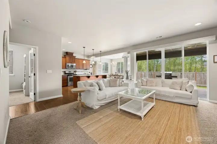 Living room w/ custom sliding glass doors leading to covered outdoor retreat w/ cozy gas stone fireplace!