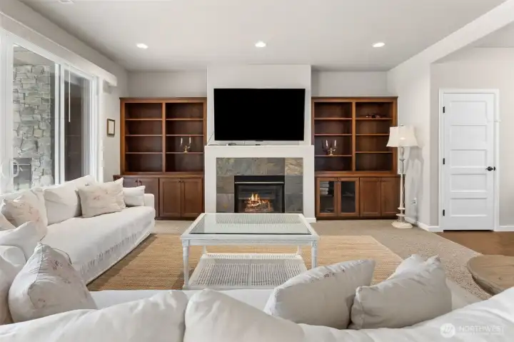 Custom built-in cabinetry w/ tiled gas fireplace.