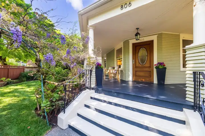 Wisteria blossoms welcome you up to the fully covered front porch, perfect for relaxing and private entertaining