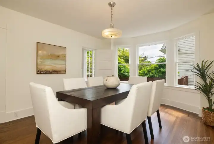 The large dining room with in-laid mahogany hard wood floors, plus a lovely bay window