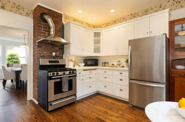 Stainless steel appliances and a hooded gas stove