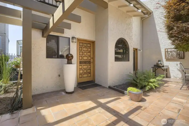 A charming Mediterranean-inspired courtyard with terracotta tile, exposed wood beams, and Spanish-style architectural details