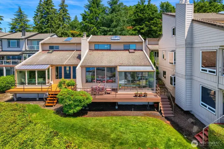Spacious outdoor deck and enclosed sunroom overlooking beautifully maintained grounds.