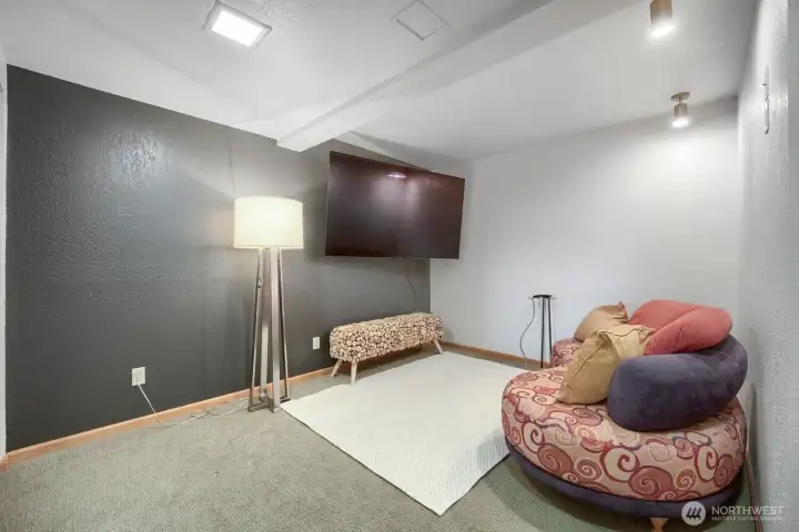 Versatile lower-level bonus room with a desk area and potential use as a home office, media room, hobby space, or additional bedroom.