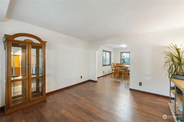 Last view of empty living room looking into dining room with new light interior paint with more wood trim and laminate wood flooring