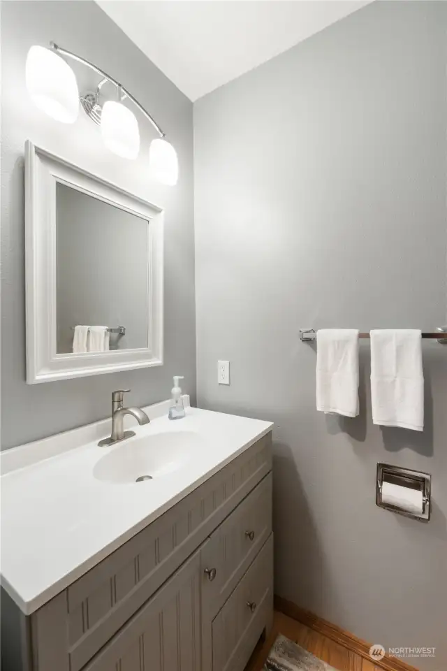 View of main floor half bathroom with new paint counters sink and lighting for your guests off entry way