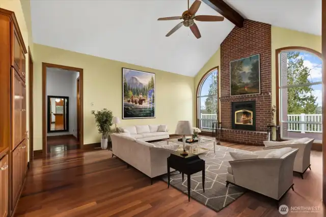 Virtually staged. Entering the cozy family room with its statement fireplace, cathedral ceiling and deck access.