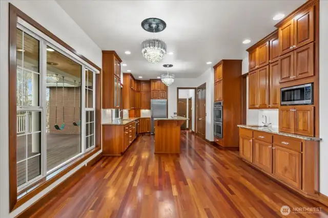 Chef's kitchen features a convenient eating space, large center island, double-door pantry and tons of cabinet storage.