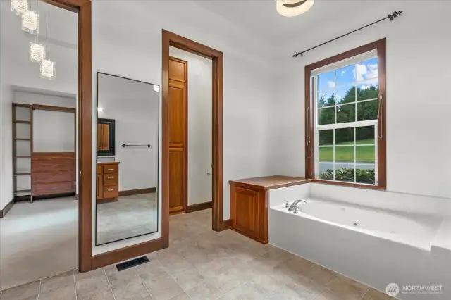 Jetted bathtub, water closet and entry to one of the walk-in closets.