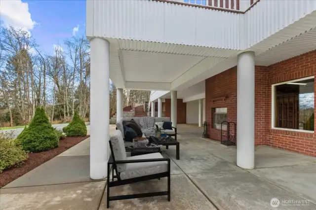 Virtually staged. Lower level covered patio featuring an outdoor fireplace.