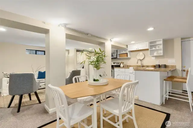 Enough room for a dining table. Kitchen has bar for stools. Door to outside is behind the stools.