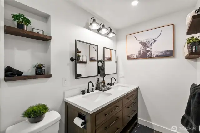 The primary en suite offers a beautifully updated 3/4 bath, showcasing a sleek and modern design.
