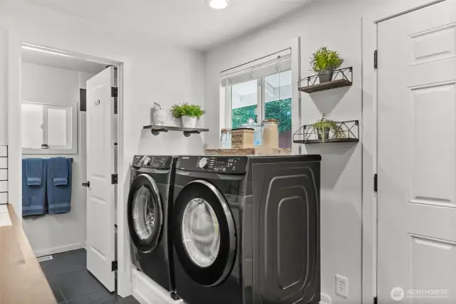 Function meets convenience in the laundry room with the elevated washer and dryer (which stay) and a side door opening directly to the dog run.