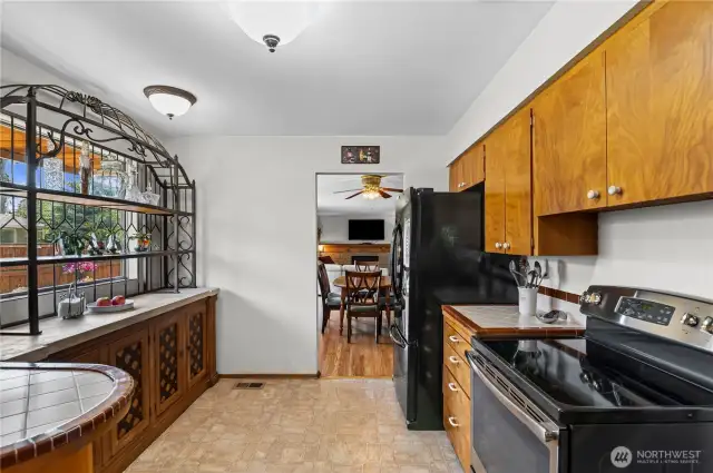 Kitchen has newer black stove and fridge