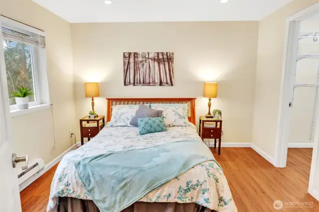 The primary bedroom has a window looking  towards the greenbelt and shown on the  right side of this photo, the entrance to the  walk-in-closet.