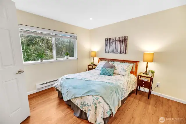 Another photo of the primary bedroom  looking towards the greenbelt. In spring,  there is a beautiful tree blooming outside this  window.