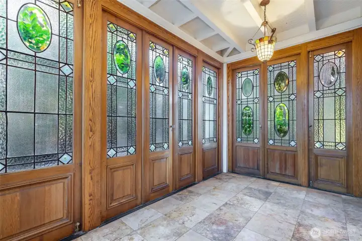 Sunroom off the kitchen is surrounded by reclaimed leaded glass doors from a French hotel.