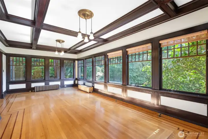 The other sunroom; this bright space with SO many windows is south facing and a delightful place to be in any season. Used as an informal living room, it can be enclosed fully.