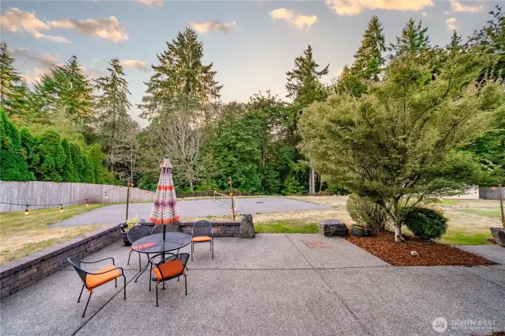 The exceptionally large back patio features skirting walls and landscape boulders