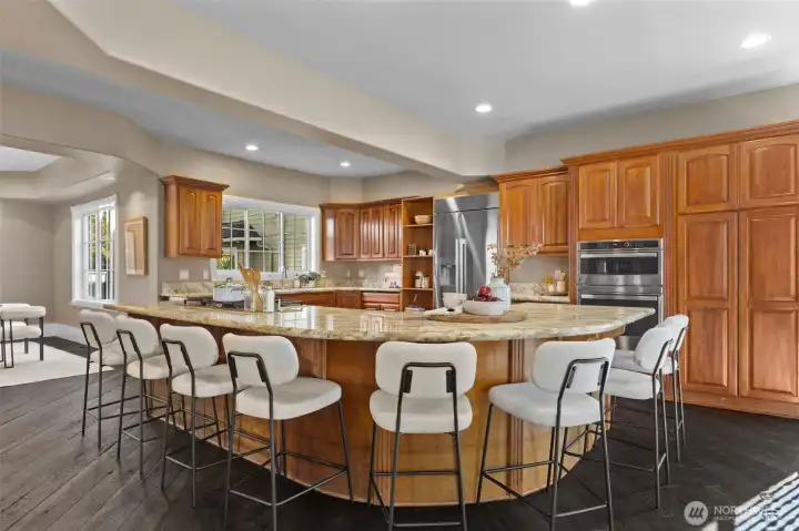 The chef’s kitchen, artfully designed with entertaining in mind, features a gorgeous 10-seat island and opens to a gracious great room