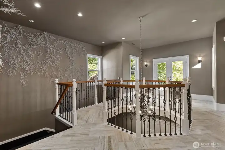 The upper level unfolds with designer tile underfoot and an inviting loft area framed by French doors and a Juliet balcony—an inspiring space for reading, relaxing, or creative pursuits.
