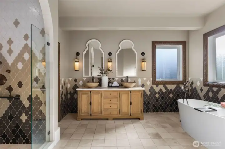 The adjoining primary bathroom is a masterwork of artistry and comfort. Awarded the Master Builders Association of King and Snohomish Counties Bath Excellence accolade in 2018 for contractor Harjo Construction, it blends timeless Moroccan finishes with modern luxury. Custom window and door trim, imported light fixtures and tile, and a floor embedded with fiber-optic lights transform evenings into a starlit retreat
