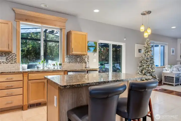 Updated kitchen with solid surface stone counters, tile backsplash, undercabinet lighting, gas range. Serene views from kitchen, dining, living.