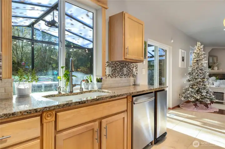 Updated kitchen with solid surface stone counters, tile backsplash, undercabinet lighting, gas range. Serene views from kitchen, dining, living.