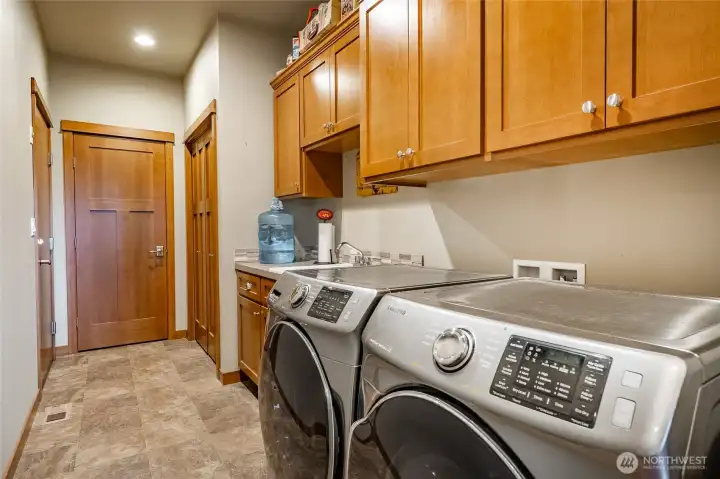 Laundry rm with lots of storage & closets, door on left leads into garage. Washer & dryer included. (new washer, not the one in photo)