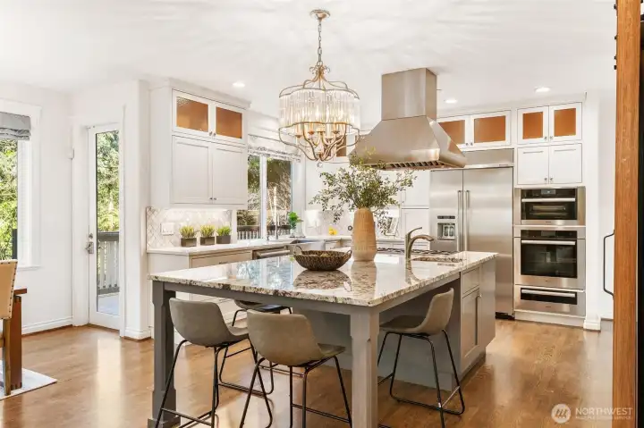 Large central island with seating and a gorgeous crystal chandelier centerpiece