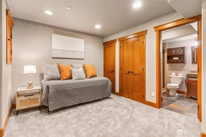 A comfortable guest wing with a nearby 3/4 bath. Whether you're catching a movie on the built-in TV or getting a morning sweat session in the private workout zone, this space has it all.