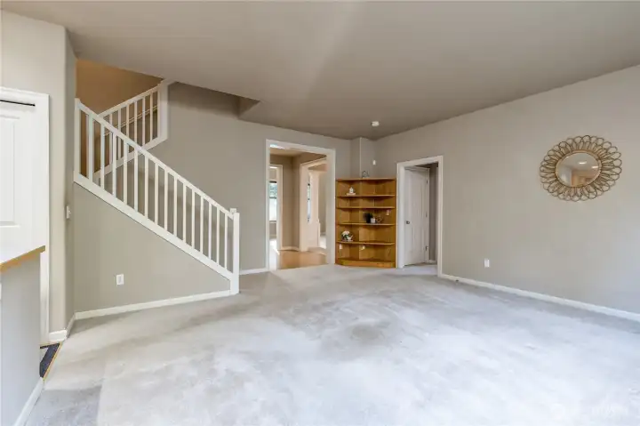 Family room is a central hub connecting to kitchen, living/dining rooms, main-floor office/bedroom, and stairway to upper level