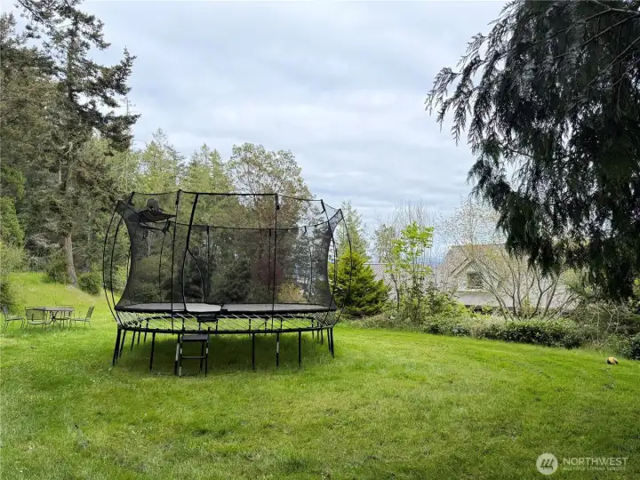 A level, upper lawn provides a natural hub for play and recreation - perfect for a trampoline or outdoor games - while also serving as the home's drain field in a seamless, functional design.
