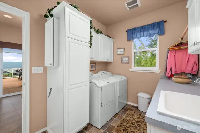 The laundry room has plenty of storage and a sink.