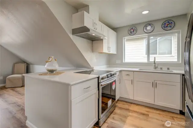 Updated kitchen includes new cabinets, quartz countertops and new stove, dishwasher and refrigerator