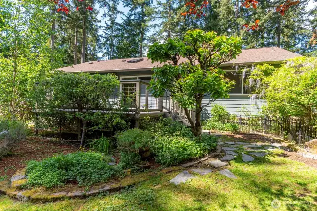 From the backyard towards the house, plenty of mature landscaping and beautiful plant and tree species!