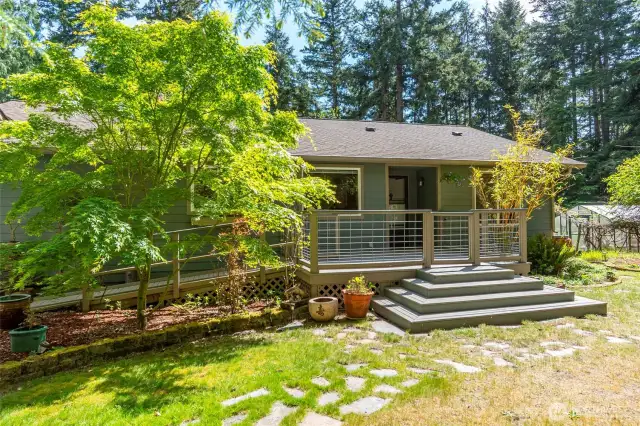 The front entrance can be approached in two way, notice the ramp which leads to a garage door entrance as well. The sunny front deck has plenty of space for entertainment and gatherings.