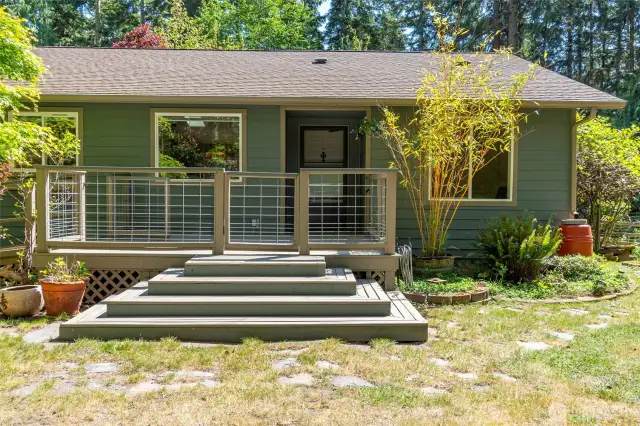 The charming front deck and entrance. Large windows throughout the home allow ample natural light.