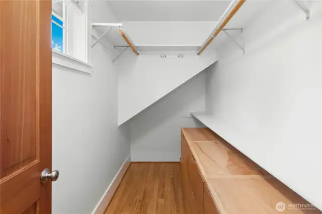 The spacious walk-in closet in the primary bedroom. A custom built-in dresser has been added to this nice space.