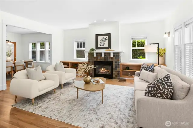 The living room is just off the entry. A cozy gas fireplace with a craftsman-style wood mantle and built-in wood bookcases are  the centerpieces of the room.