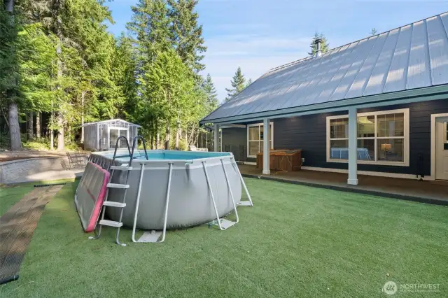 Above ground pool with the greenhouse in the background.