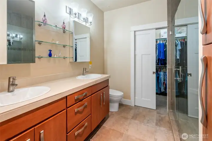 Upscale spa like primary bathroom with radiant heated tile floors! Pocket door to Wardrobe closet!