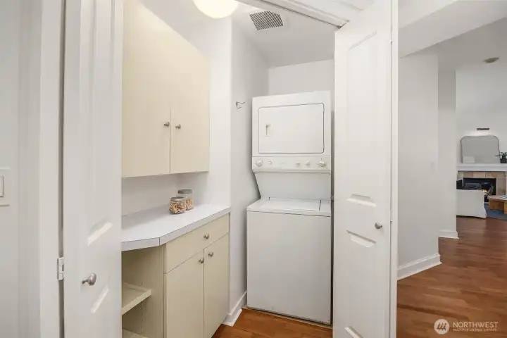 Laundry room off entry with washer/dryer and storage.