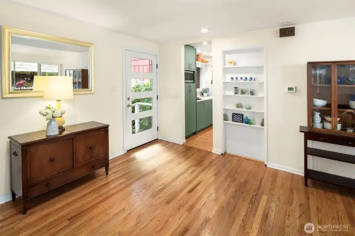 The bright entry is shown here, highlighting the charming built-ins and gorgeous hardwood floors.