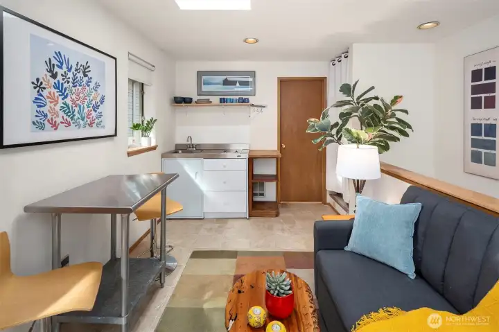 The bright living space in the studio, note the sweet kitchenette; not pictured here is storage and the full bathroom