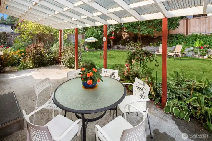 The covered patio looks out to your lovely backyard. The retaining wall is new as of 2024.