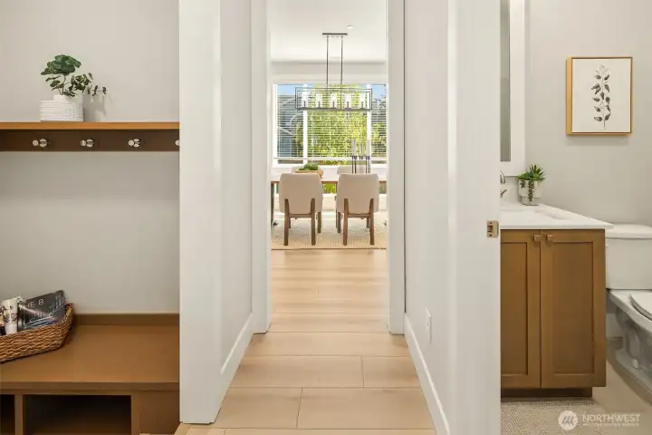 Hall from main level bed/den. Mudroom and 3/4 bath lead into dining area.