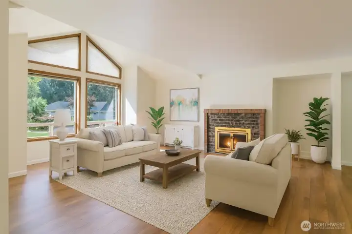 Beautiful wide vinyl plank flooring throughout, vaulted ceiling, fireplace, and those windows just welcome in the natural light. (Virtually staged)